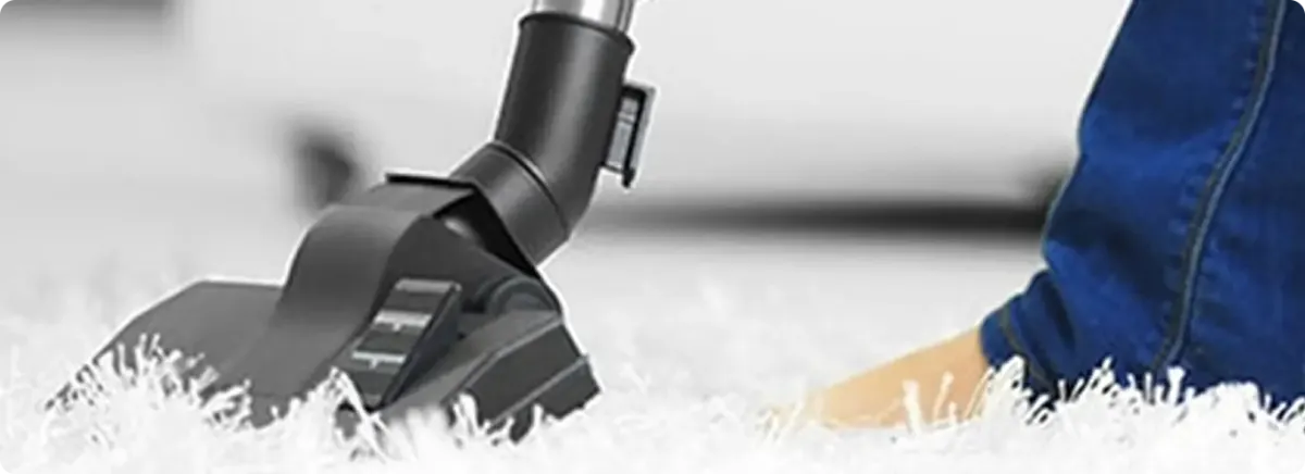 Close-up of a professional vacuuming a white carpet in Ridgeland.